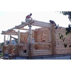 Бригада строителей выполнит сборку деревянных домов.